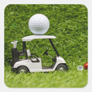 Golf Ball on Golf Cart on Green Grass Quadratischer Aufkleber