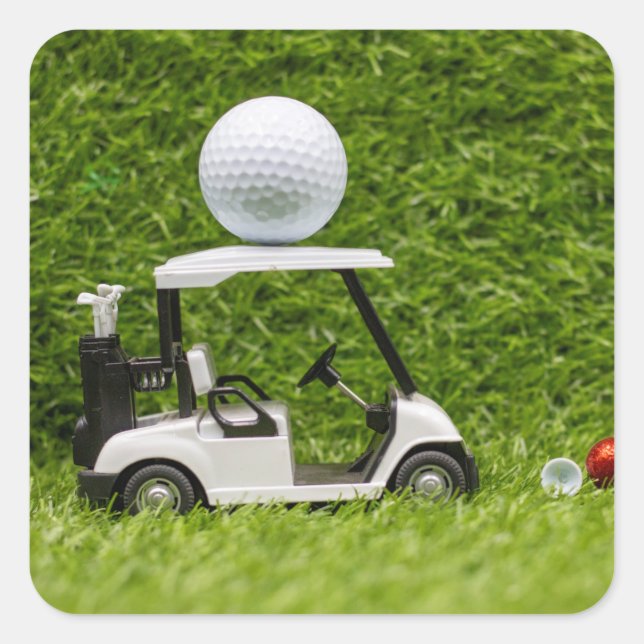 Golf Ball on Golf Cart on Green Grass Quadratischer Aufkleber (Vorderseite)