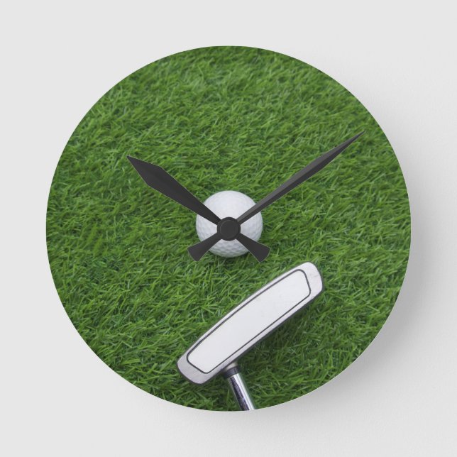 Golfball mit Putter sind auf grünem Gras Runde Wanduhr (Vorderseite)