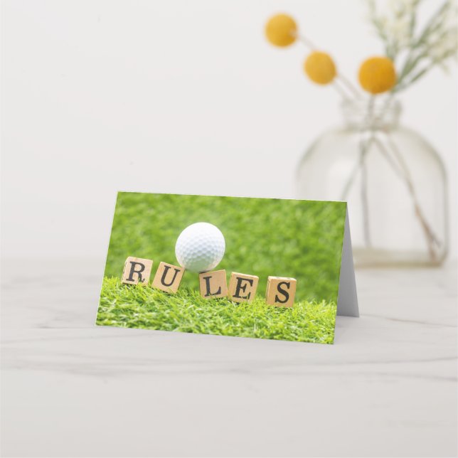 Golfball mit RULES auf grünem Gras Platzkarte (Vorderseite)