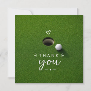 Golfball neben Loch auf grünem Gras Danke