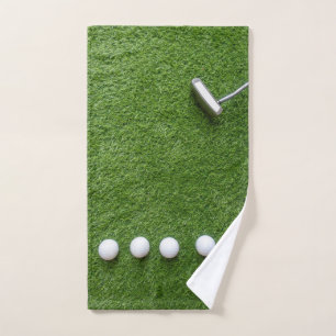 Golfbälle mit Putter sind auf grünem Gras Handtuch