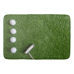 Golfbälle sind auf grünem Rasenbad Badematte