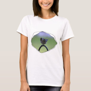 Grasmücke saß auf zerrissenem Material T-Shirt