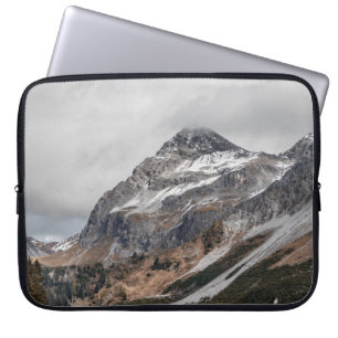 GRAUE BERGE MIT SCHNEEBEDACHT UMGEBEN VON BÄUMEN LAPTOPSCHUTZHÜLLE