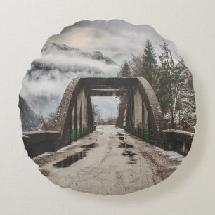 GRAUE BETONBOGENBRÜCKE NEBEN BLATTLOSEM BAUM IN DE RUNDES KISSEN