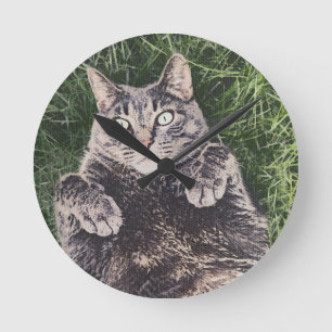 graue Katze liegt im Gras Digitale Kunst Runde Wanduhr