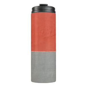 Graue und orangefarbene Wand Thermosbecher