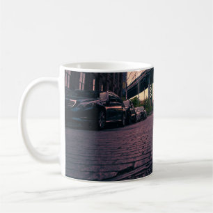 GRAUES FAHRZEUG AN DER STRASSE NEBEN BETONGEBÄUDE KAFFEETASSE
