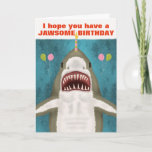 Great White Shark Funny Jawsome Birthday Pub Spaß Karte<br><div class="desc">Der Große Weiße Hai auf dieser lustigen Grußkarte ist so nett. Sehen Sie? Es lächelt und hofft, dass du einen knöchernden Geburtstag hast. Es brachte sogar Ballons und balancierte eine Kerze auf die Nase. Das Design umfasst einen von Hand gezeichnet Hai auf einem blau / meergrün Hintergrund mit den Silhouetten...</div>