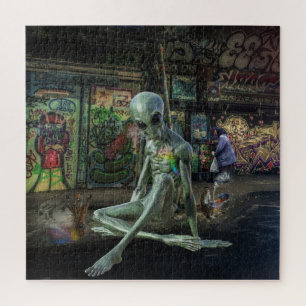 GREEN GREY ALIEN SITTING ON PAPER WITH GRAFFITI PUZZLE