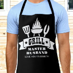 Grill Master Husband Black Schürze<br><div class="desc">Diese schwarze Schürze zeigt die Illustrationen eines Grillgrillgrills und des "Grill Master Husband" in lustiger Typografie.</div>