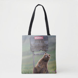 Grizzlybär spielt mit Schild