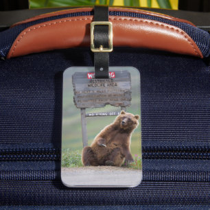 Grizzlybär spielt mit Schild Gepäckanhänger