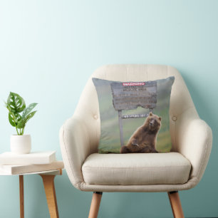 Grizzlybär spielt mit Schild Kissen