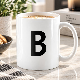 Großer schwarzer Anfangsbuchstabe minimalistisches Kaffeetasse