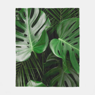 Grüne Monstera-Blätter und Blätter aus Palmen Fleecedecke