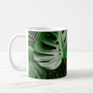 Grüne Monstera-Blätter und Blätter aus Palmen Kaffeetasse