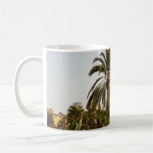 Grüne Palmen in der Nähe von braunem Beton Gebäude Kaffeetasse