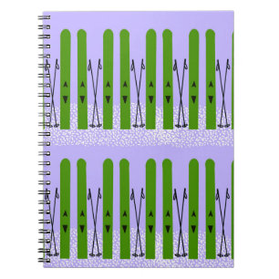 Grüne Skier auf lila Notebook Notizblock