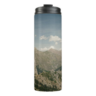 GRÜNE UND BRUNNE BERGE WÄHREND DER JAHRESZEIT UNTE THERMOSBECHER