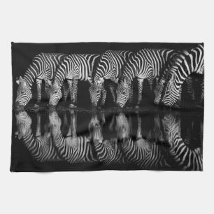 Gruppe von Steppenzebras trinkt nachts zusammen Geschirrtuch