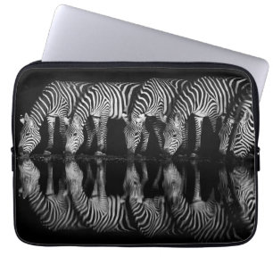 Gruppe von Steppenzebras trinkt nachts zusammen Laptopschutzhülle