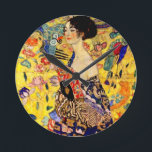 Gustav Klimt Lady mit Fan Runde Wanduhr<br><div class="desc">Uhr mit Gustav Klimts Ölgemälde Lady mit Fan (1918). Eine Frau,  die einen blauen Kimono trägt,  hält einen roten Fan vor einem bunten,  gelben Hintergrund von Blume und Pfauen. Ein großartiges Geschenk für die Fans von Japonisme und europäischer Kunst.</div>