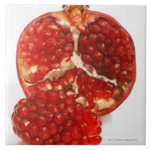 Hälfte ein reifer Granatapfelschnitt, zum das Fliese