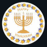 hanukkah menorah Aufkleber<br><div class="desc">Eine goldene Menorah umgeben von einem Kreis goldener und blauer Sterne mit den Worten "Happy Hanukkah". Der Hintergrund ist weiß,  kann aber in jede der vielen Farbvarianten von Zazzle geändert werden.</div>
