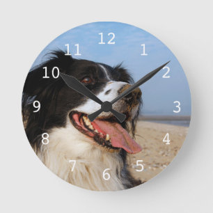 Happy dog at the beach runde wanduhr