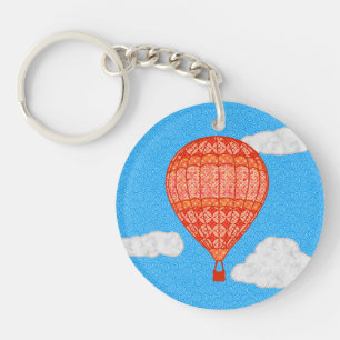 Heißluftballon, Korallenorange gegen einen blauen Schlüsselanhänger