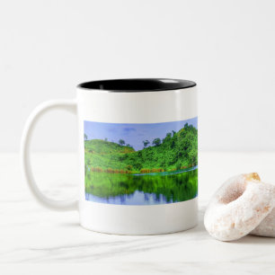 Hintergrund des tropischen Sees und der üppigen Wä Zweifarbige Tasse