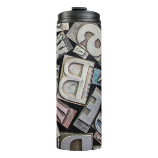 Hintergrund von zufälliger Vintage-Grunge-Letterpr Thermosbecher