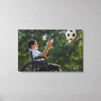 Hispanischer Junge, 8, im Rollstuhl mit Fußball Leinwanddruck