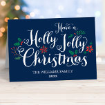 Holly Jolly Christmas Navy Blue Foto Feiertagskarte<br><div class="desc">"Have a Holly Jolly Christmas" holiday greeting cards feature a dark navy blue background,  white handwritten style script,  and festive berries,  holly leaves,  poinsettia,  and winter evergreen design accents. Personalize with hat Foto und Kustom Botschaft an die Inside.</div>