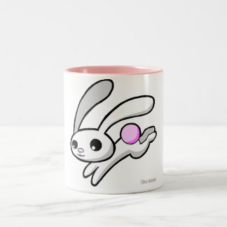 Hop das Kaninchen mit der trinkenden Tasse des