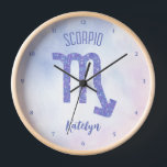 Hübsches Skorpio Astrologie Signieren Personalisie Uhr<br><div class="desc">Diese hübsche lila und lavendere Scorpio Uhr zeigt Ihr astrologisches Zeichen aus dem Zodiac in einem schönen Funkeln wie die Sternbilder. Passen Sie dieses niedliche Geschenk mit Ihrem Namen in kursiver Schrift für jemanden mit einem Geburtstag Ende Oktober oder Anfang November Geburtstag an.</div>
