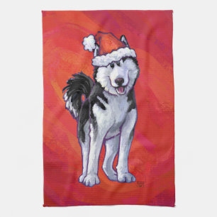 Husky in Weihnachtsmannmütze auf Rot Geschirrtuch