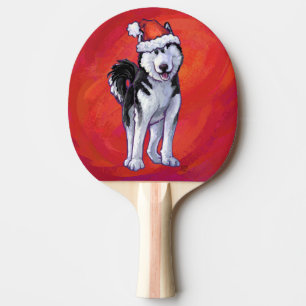 Husky in Weihnachtsmannmütze auf Rot Tischtennis Schläger