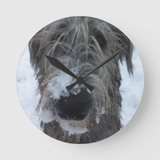 irischer Wolfhound, der im Schnee spielt Runde Wanduhr