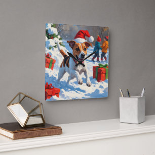 Jack Russell läuft im Schnee mit Weihnachtsmütze Quadratische Wanduhr