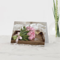Jahrgangswein und rosa Tulpen auf Satinlaken