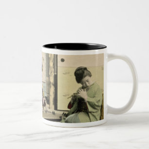 Japanische Mädchen, welche die Flöte, "den Koto" Zweifarbige Tasse