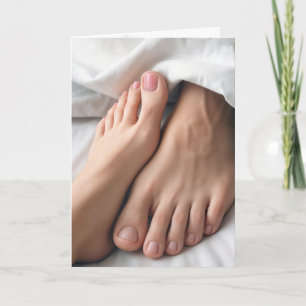 Jubiläumsmensch und Frauenfüße auf einem Bett Karte