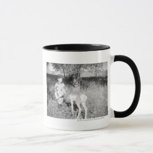 Junge, der eigenhändig Antilope füttert Tasse