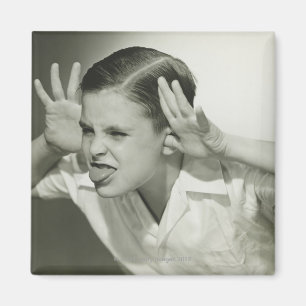 Junge, der sich ins Gesicht stellt Magnet