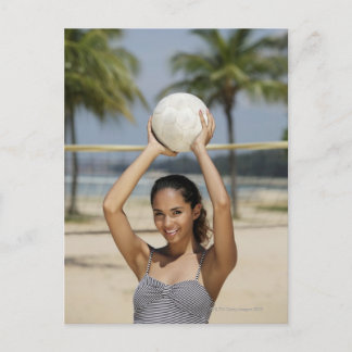 Junge Frau, die Volleyball hält und lächelt bei Postkarte