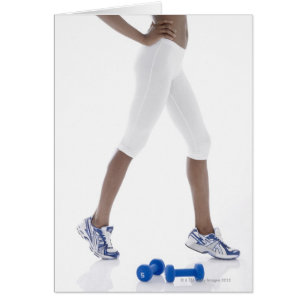Junge Frau mit dem Dumbbellsausdehnen (Tief