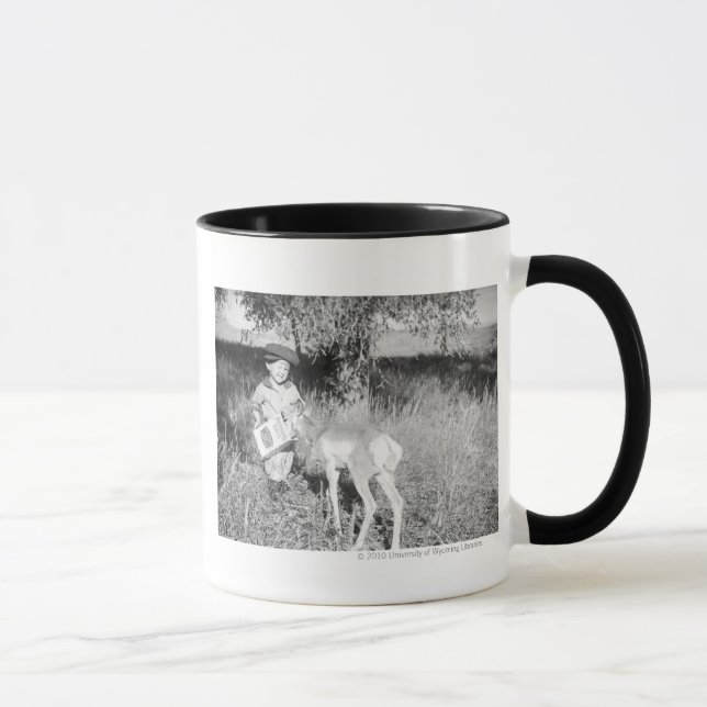 Junge füttert Antilope von Hand Tasse (Rechts)
